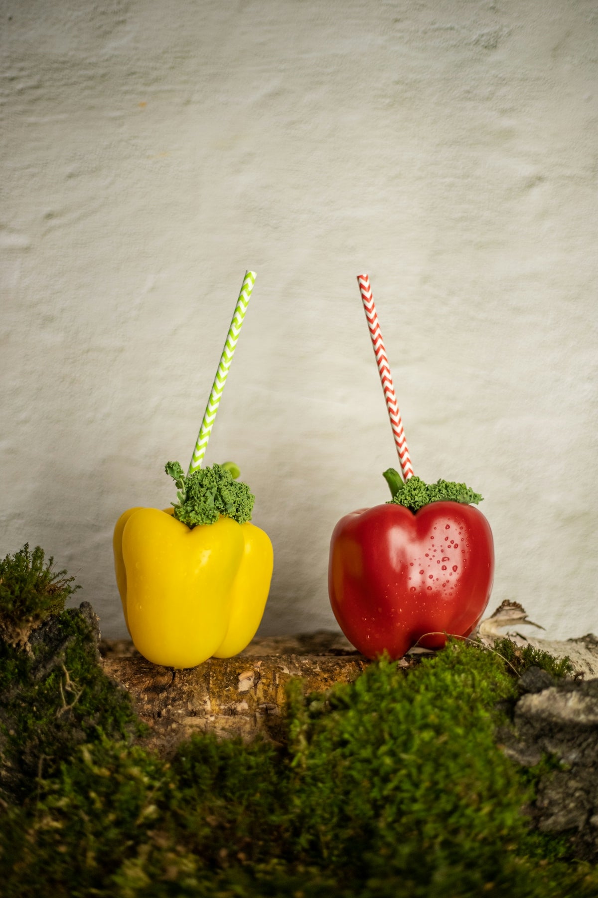 a couple of red and yellow peppers sitting next to each other